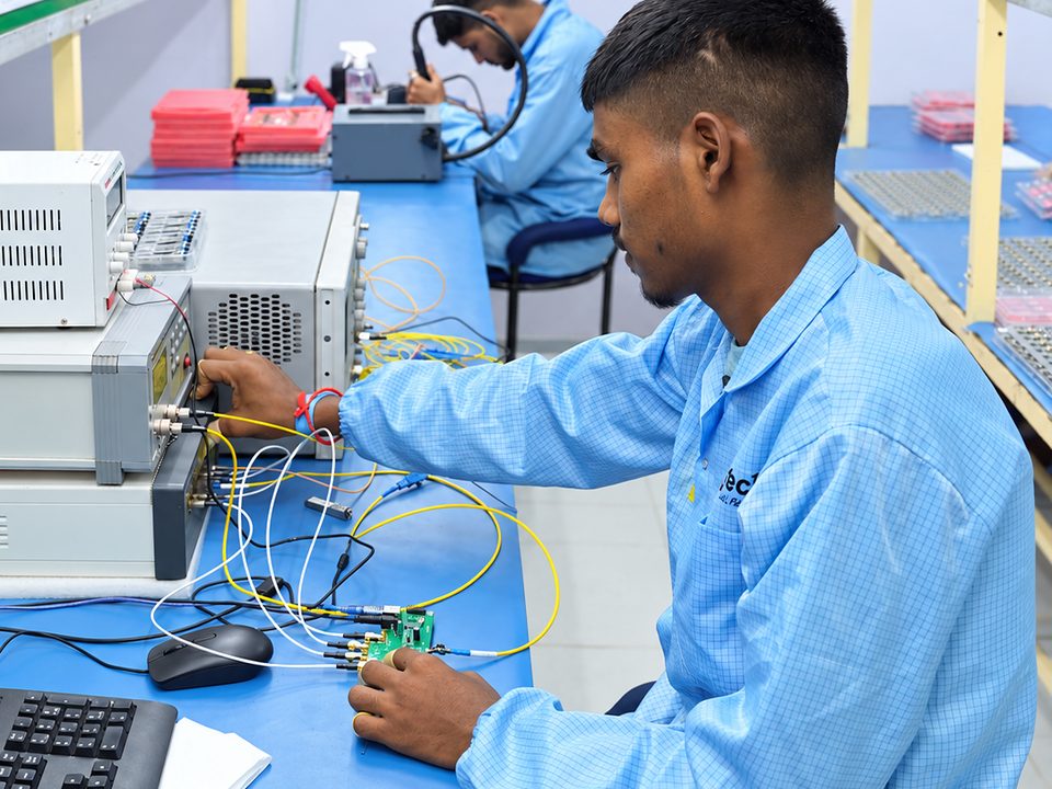A Syrotech technician testing a circuit board with fiber cables